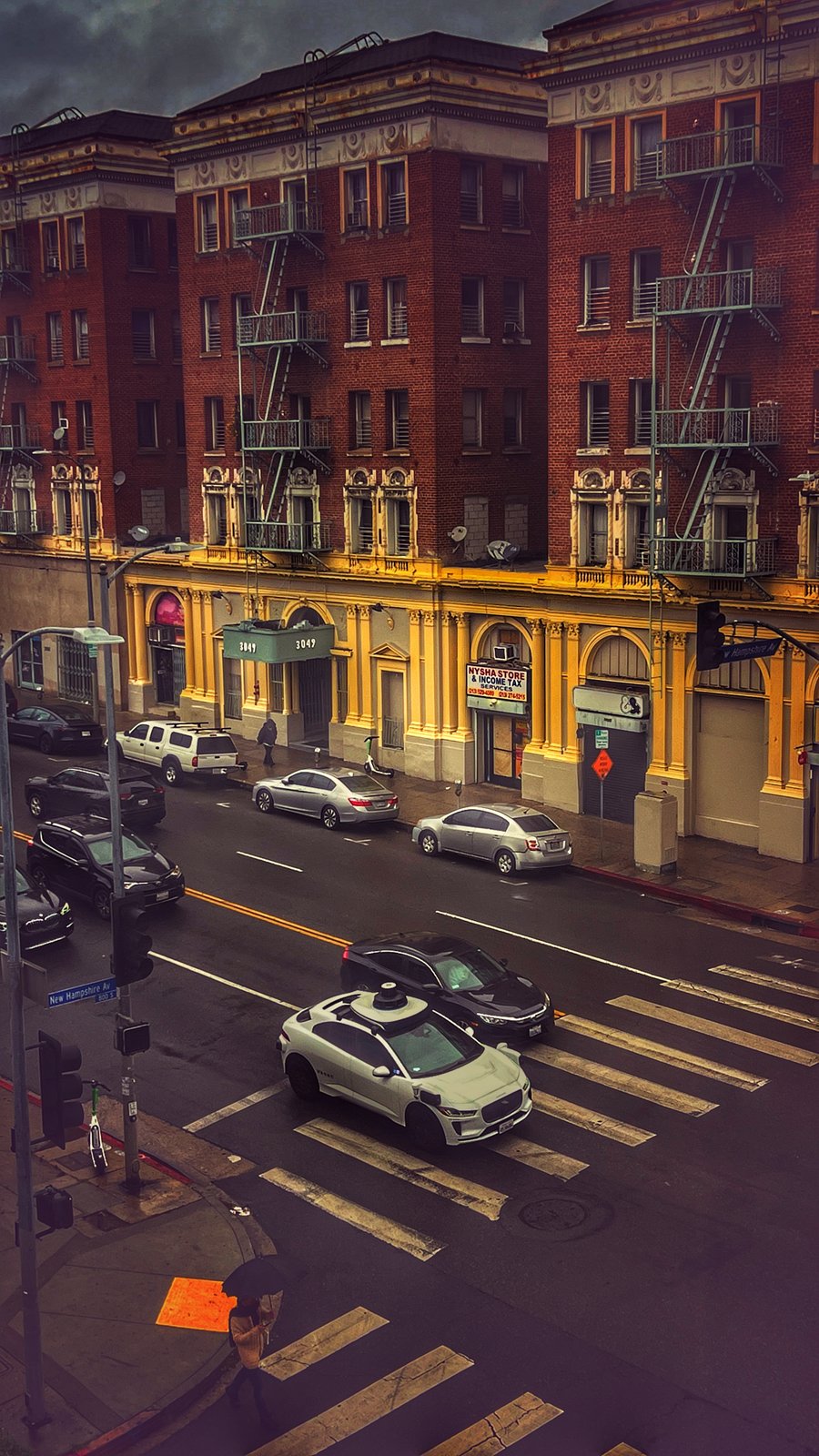 LA street in the rain — brick and fire escapes